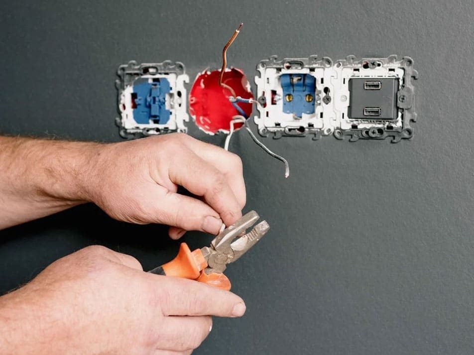 Electrician Using Pliers To Repair The AC Power Plugs And Sockets — Coughran Electrical Electrician services in Northern Rivers Byron, NSW